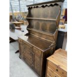 A PRIORY STYLE OAK DRESSER WITH TWO DOORS, SIX DRAWERS AND UPPER PLATE RACK