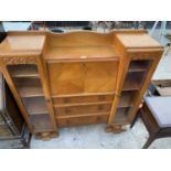 AN OAK SIDE BY SIDE CABINET WITH FALL FRONT, THREE DRAWERS AND TWO GLAZED DOORS