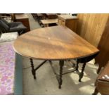 AN OVAL OAK DROP LEAF DINING TABLE ON BARLEY TWIST SUPPORTS