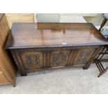 AN OAK BLANKET CHEST WITH HINGED TOP AND THREE CARVED PANELS