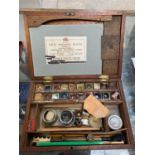 A WOODEN PAINT BOX CONTAINING ASSORTED ARTIST SUPPLIES