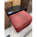 AN UPHOLSTERED FOOTSTOOL AND A BLACK GLASS TV STAND