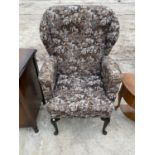 A WING BACK ARMCHAIR ON MAHOGANY CABRIOLE SUPPORTS
