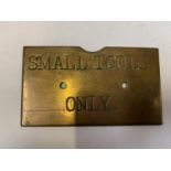 A SMALL BRASS SIGN 'SMALL TOOLS ONLY'