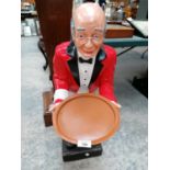A LARGE RESIN MODEL OF A WAITER HOLDING A TRAY