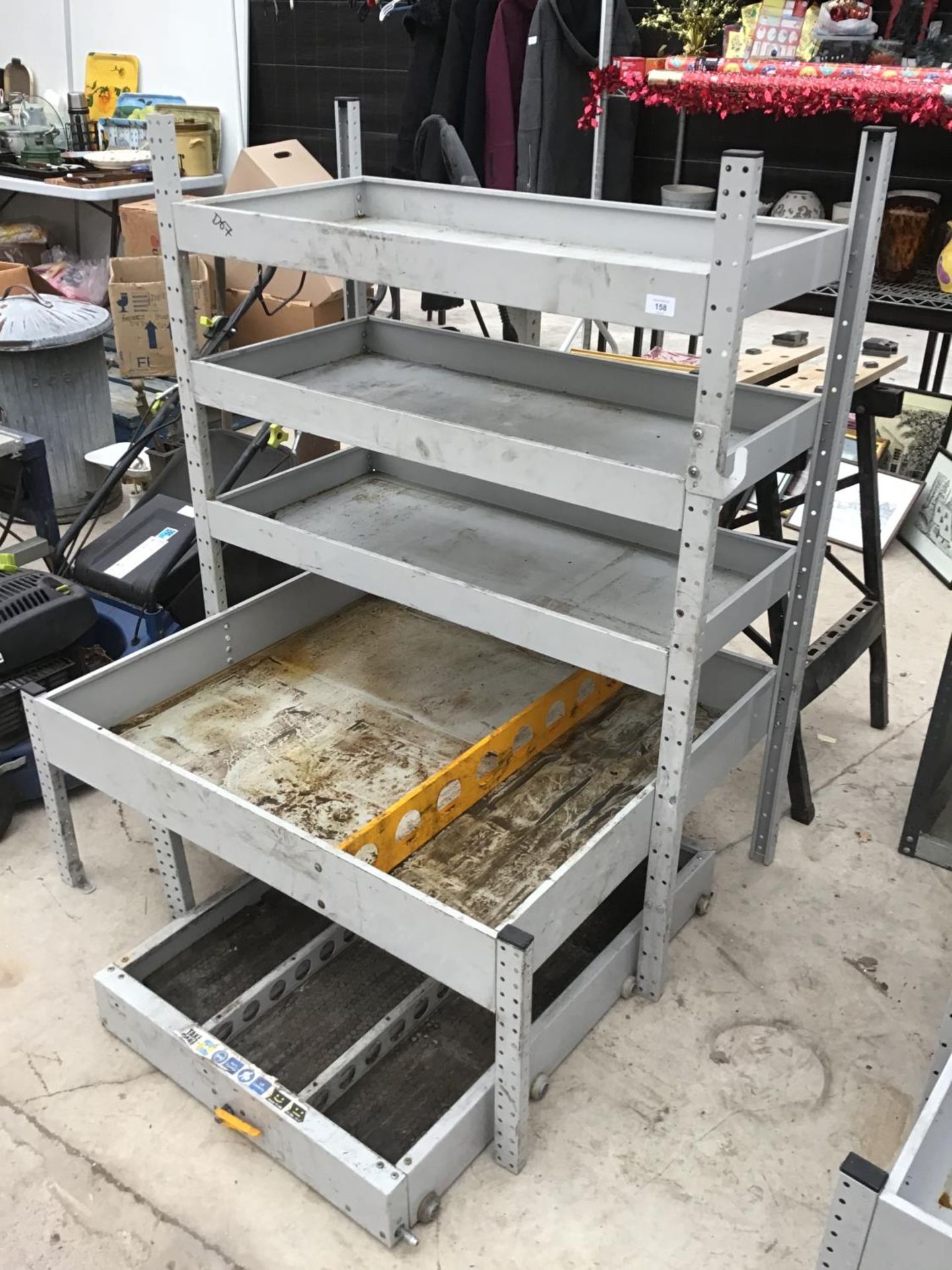 A METAL RACKING FOUR SHELF STORAGE UNIT WITH WHEELED UNDER STORAGE TRAY