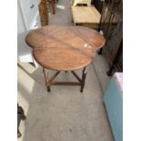 AN OAK CLOVER LEAF SHAPED TRIANGULAR DROP LEAF OCCASIONAL TABLE ON CARVED AND TURNED SUPPORTS