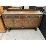 AN OAK SIDEBOARD WITH FOUR DOORS, TWO CARVED FRONT DRAWERS AND SPLASHBACK