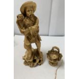 AN ORIENTAL FIGURE WITH BASKET