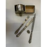 A HALLMARKED SILVER NAPKIN, THREE PIECES OF CUTLERY AND TWO THIMBLES, ONE CHESTER EXAMPLE