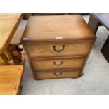 A TEAK BEDSIDE CABINET WITH THREE DRAWERS HAVING RECESSED BRASS HANDLES