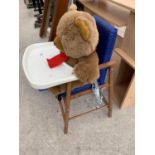 A WOODEN HIGH CHAIR WITH A TEDDY