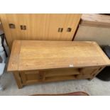 A MODERN OAK COFFEE TABLE WITH TWO DOORS AND LOWER SHELVING