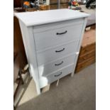 A WHITE CHEST OF FOUR DRAWERS