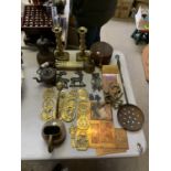 A COLLECTION OF ASSORTED BRASS BADGES, TWO CANDLE STICKS ETC