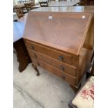 A BURR WALNUT BUREAU ON CABRIOLE SUPPORTS WITH FALL FRONT AND THREE DRAWERS