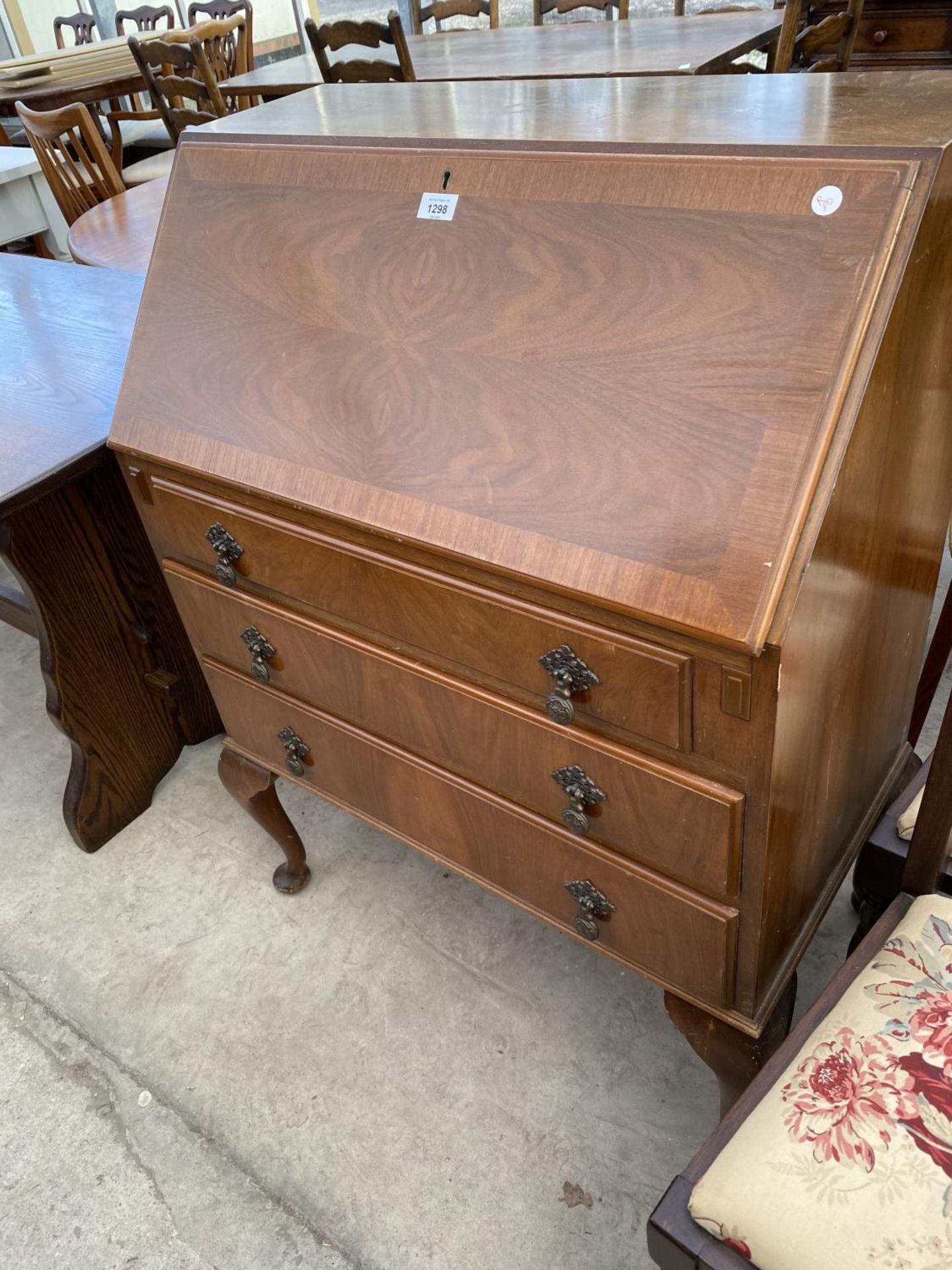 A BURR WALNUT BUREAU ON CABRIOLE SUPPORTS WITH FALL FRONT AND THREE DRAWERS