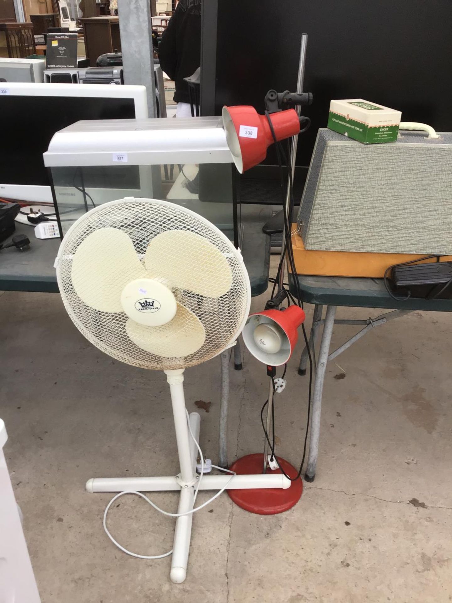 A TWO LAMP RED SPOT LIGHTS ON A STAND AND A FAN