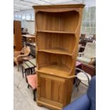 A PINE CORNER CABINET WITH LOWER DOORS AND SHELVING