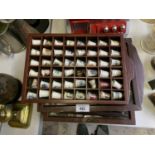 A LARGE COLLECTION OF CERAMIC THIMBLES IN DISPLAY CASES