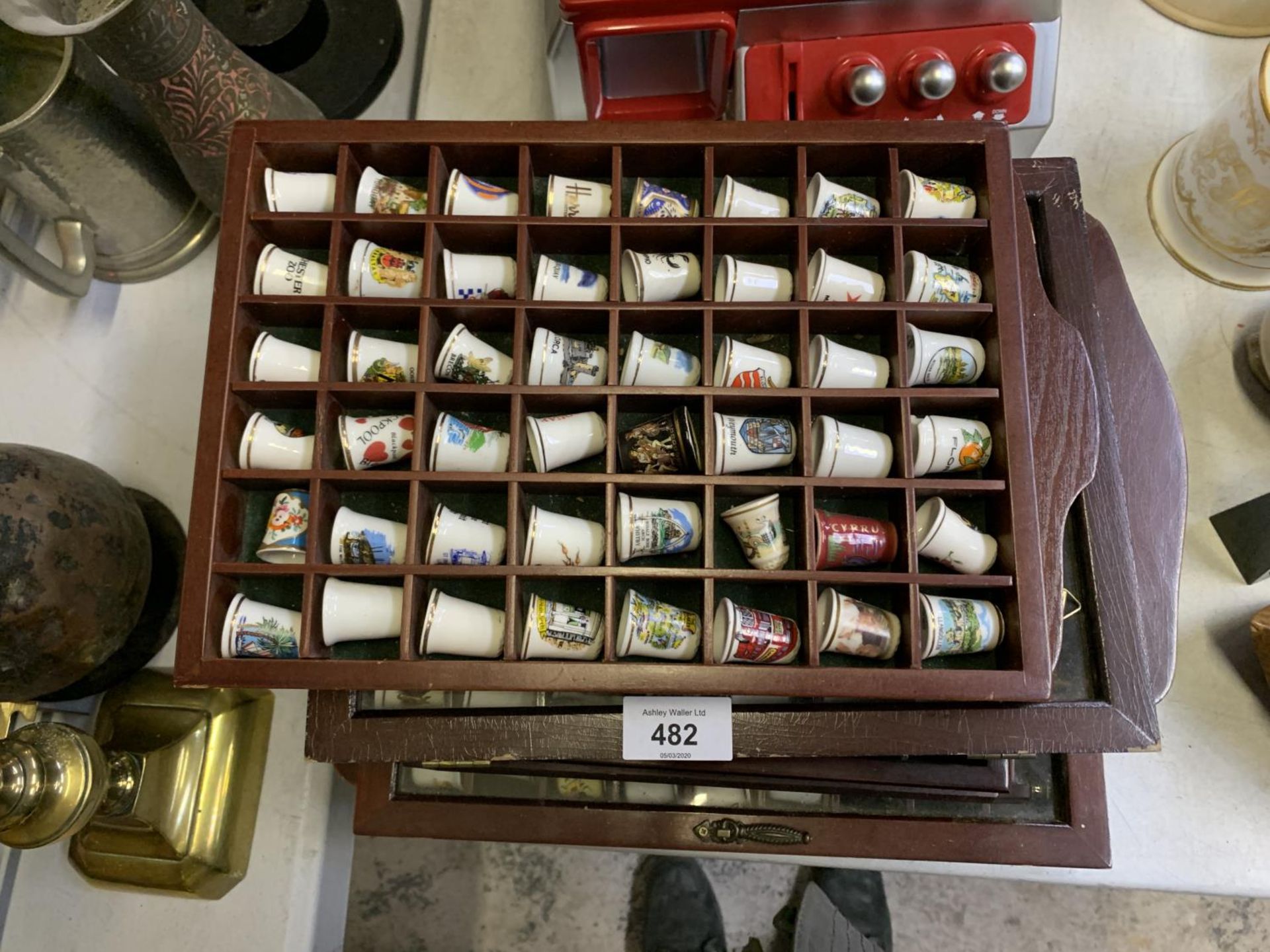 A LARGE COLLECTION OF CERAMIC THIMBLES IN DISPLAY CASES