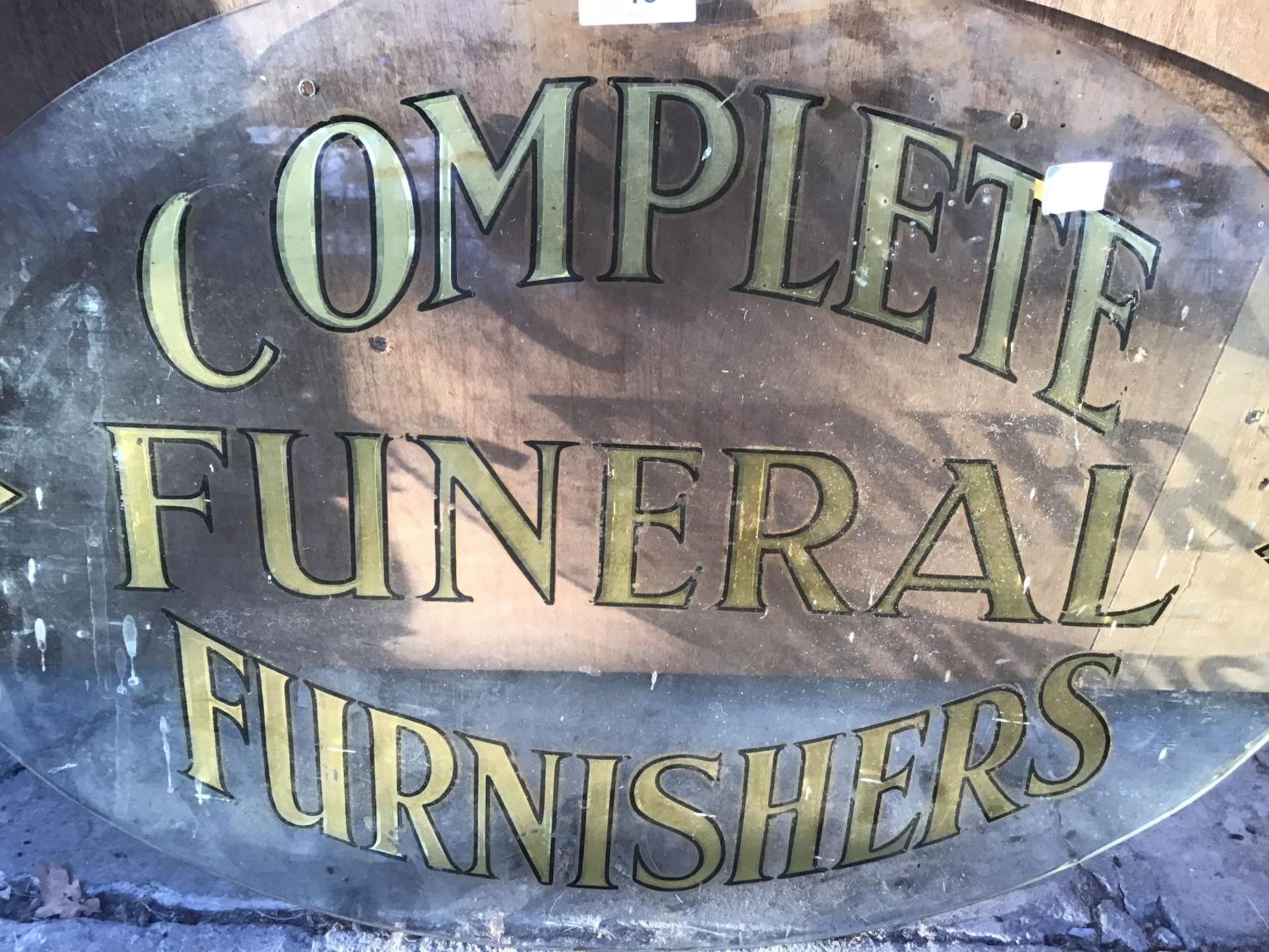 AN OVAL GLASS SIGN PAINTED WITH 'COMPLETE FUNERAL FURNISHERS' AND A FURTHER GLASS HANGING PLAQUE ( - Image 2 of 2