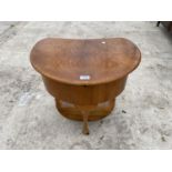 A WALNUT KIDNEY SHAPED SEWING TABLE WITH SILK LINING AND LOWER SHELF