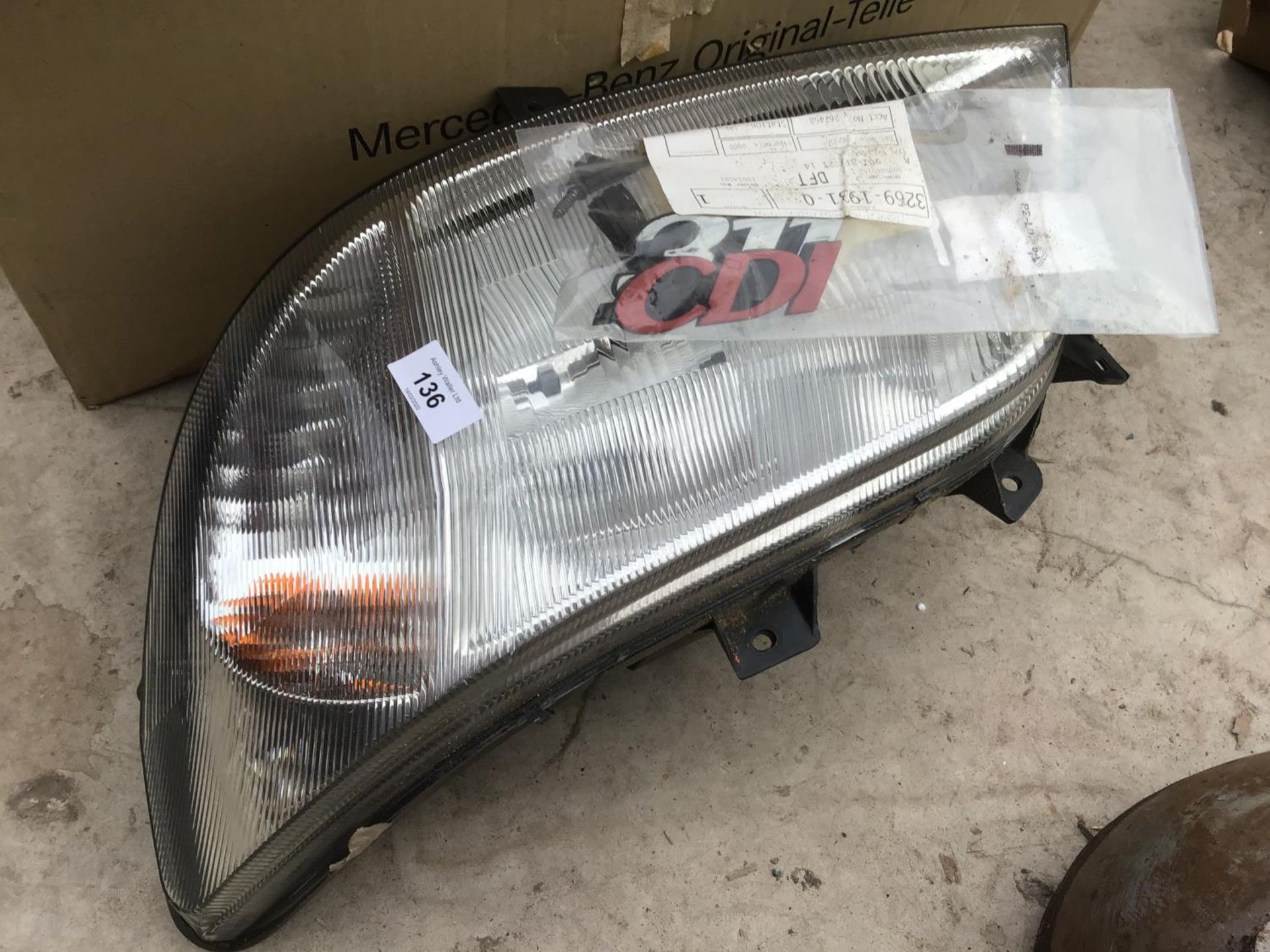 A NEW AND BOXED FRONT LIGHT UNIT FOR A MERCEDES SPRINTER VAN AND SOME BADGES