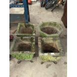 FOUR CONCRETE PLANTERS ON WROUGHT IRON LEGS