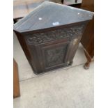 AN OAK FLAT FRONT CORNER CUPBOARD WITH CARVED PANEL DOOR