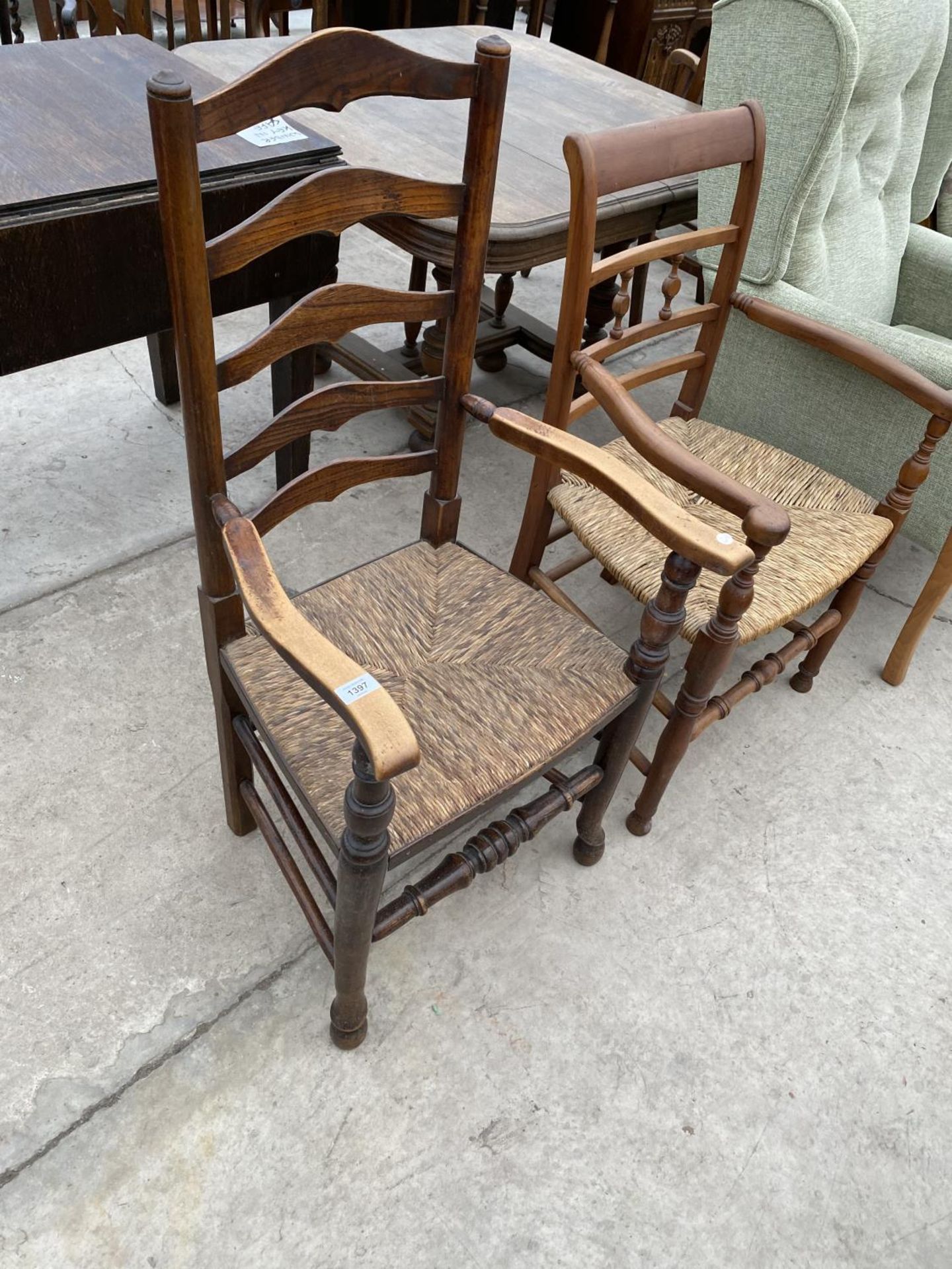 TWO LADDER BACK CARVER DINING CHAIRS WITH RUSH SEATS - ONE OAK, ONE MAHOGANY