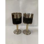 A PAIR OF CHROME DRINKING GOBLETS WITH INTRICATE CARVED IVORY STEMS