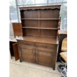 A PRIORY STYLE OAK DRESSER WITH TWO DOORS, TWO DRAWERS AND UPPER PLATE RACK