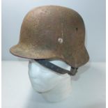 A GERMAN RUSTED AND GREEN PAINTED HELMET