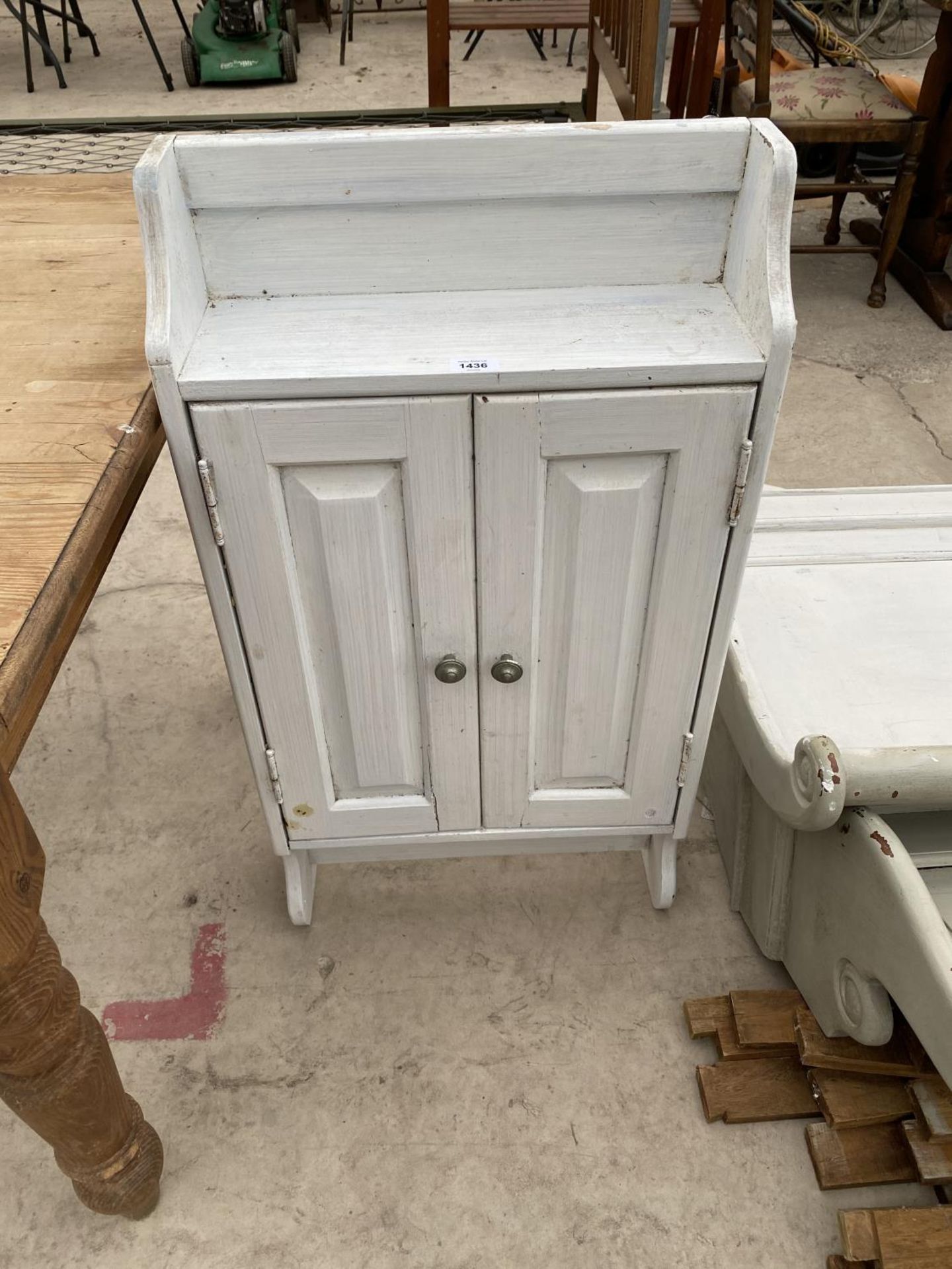 A SMALL WHITE PAINTED CABINET WITH TWO DOORS