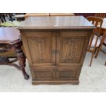 AN OAK CABINET WITH LOWER FALL FRONT AND TWO DOORS