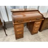 AN OAK ROLL TOP DESK WITH EIGHT DRAWERS