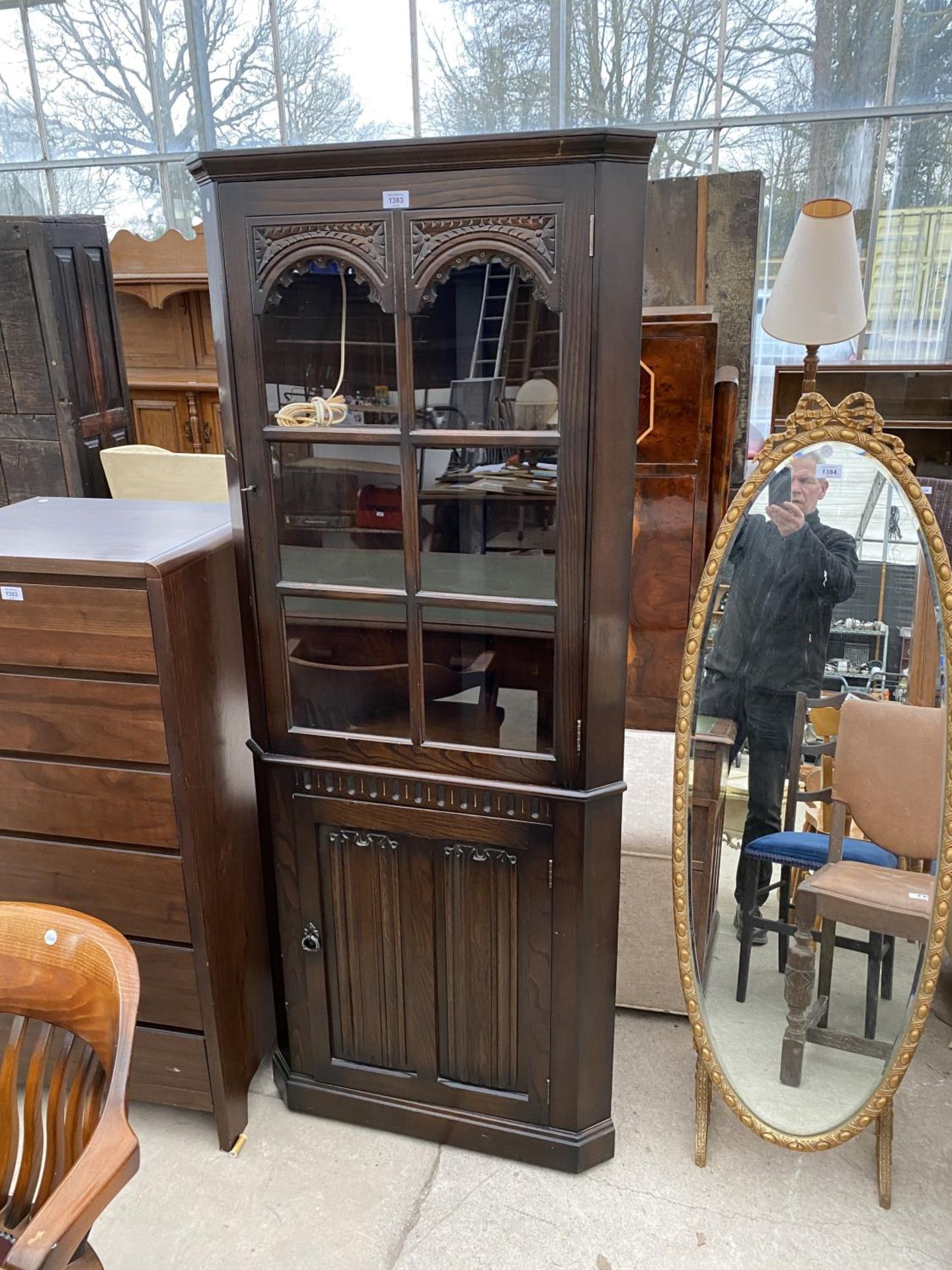 A JAYCEE OAK CORNER CABINET WITH LOWER DOOR AND UPPER GLAZED PANEL DOOR