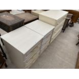 TWO CREAM BEDSIDE CHESTS OF THREE DRAWERS AND A CREAM CHEST OF THREE DRAWERS