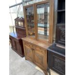 AN OAK CABINET WITH TWO LOWER DOORS AND DRAWERS AND TWO UPPER GLAZED DOORS