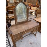 AN ARTS AND CRAFTS STYLE OAK DRESSING TABLE WITH TWO DOORS, ONE DRAWER AND ARCHED UPPER MIRROR