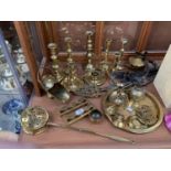 A COLLECTION OF BRASSWARE TO INCLUDE CANDLE STICKS, TRIVET STANDS, BADGES ETC