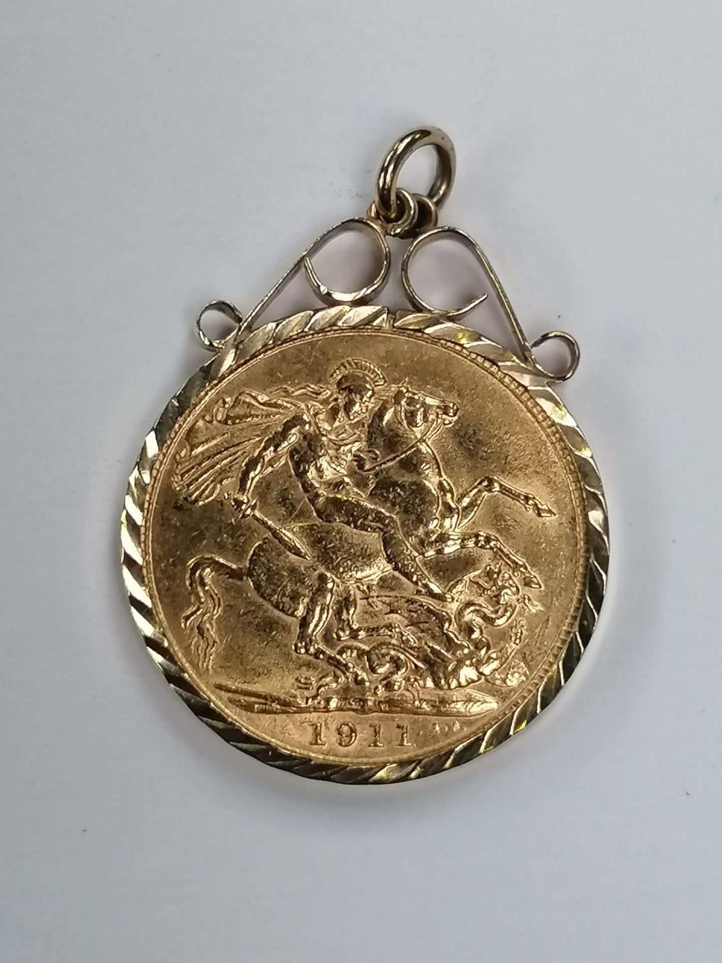 A 1911 GOLD FULL SOVEREIGN IN 9CT GOLD MOUNT, GROSS WEIGHT 9.2 G