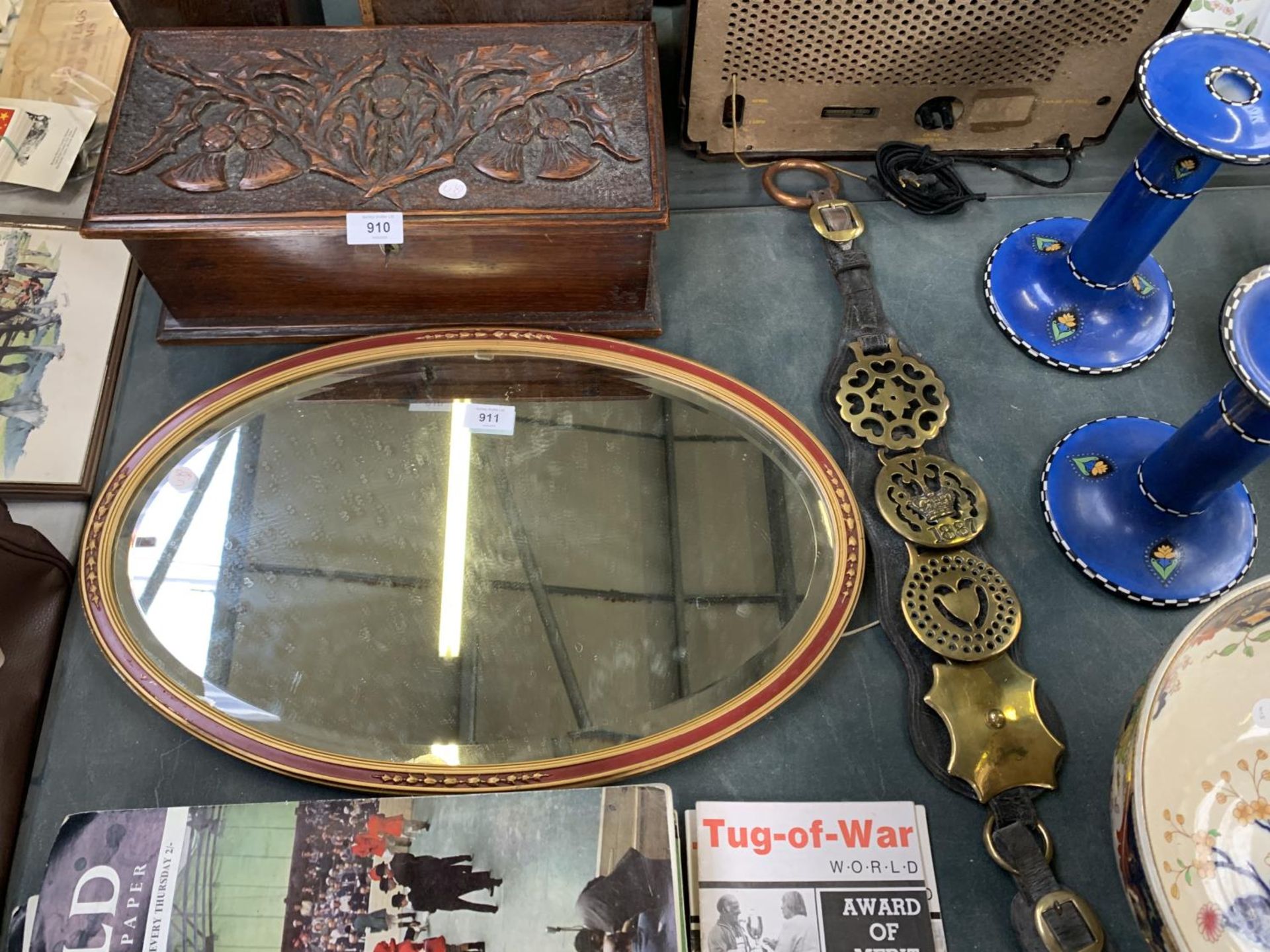 A OVAL MIRROR TOGETHER WITH A BELT AND BRASS BADGES