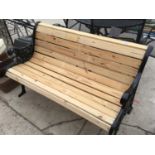 A WOODEN BENCH WITH CAST IRON BENCH ENDS