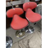 TWO RED BAR STOOLS ON CHROME SWIVEL SUPPORTS