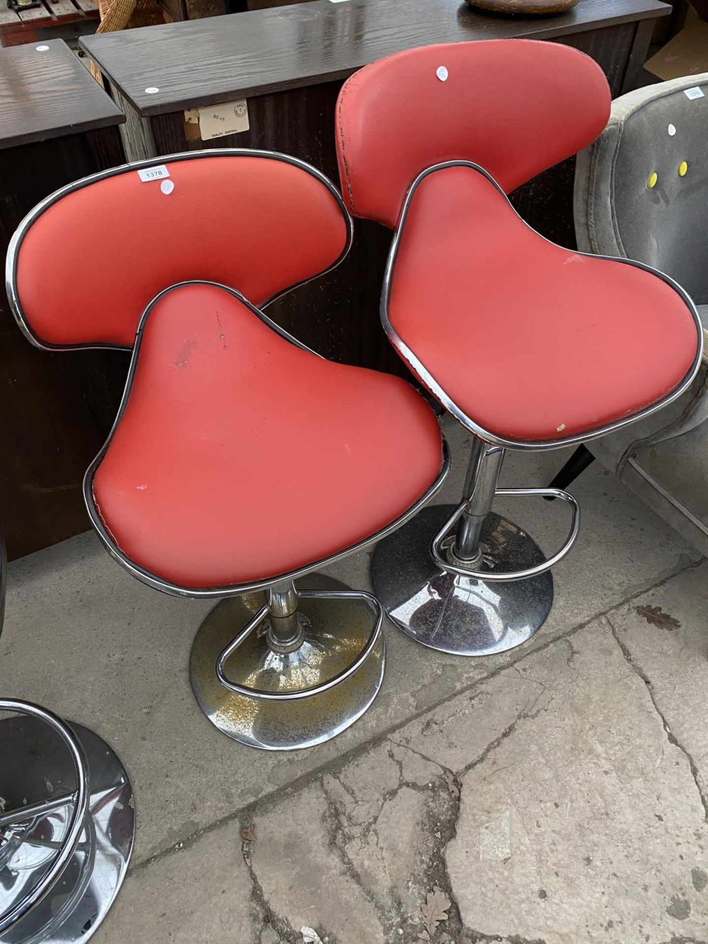 TWO RED BAR STOOLS ON CHROME SWIVEL SUPPORTS