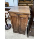 A SMALL OAK CABINET WITH TWO DOORS