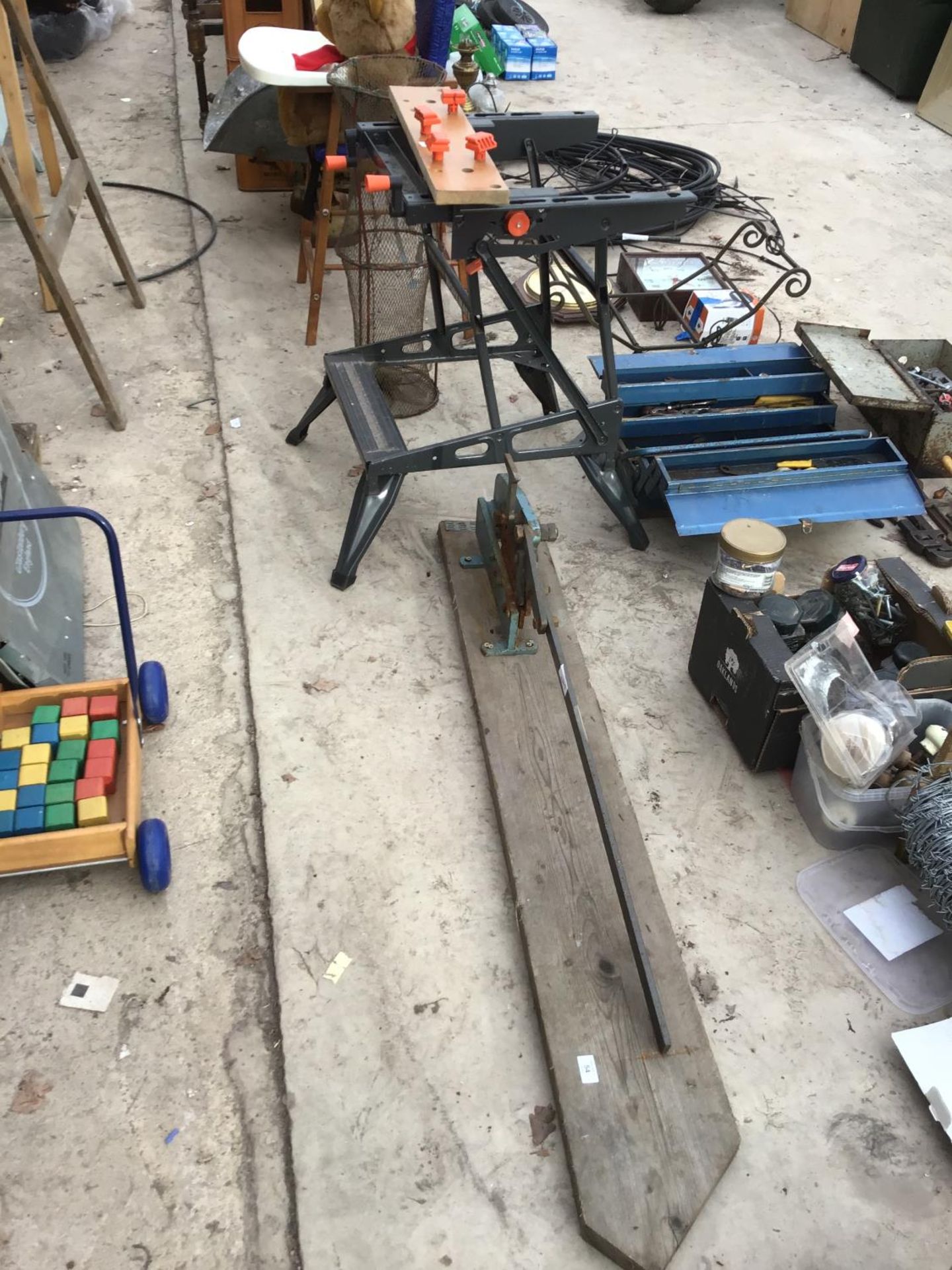 A HEAVY DUTY TIN CUTTER ON A WOODEN BASE AND A BLACK AND DECKER WORK BENCH