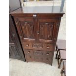 AN OAK CABINET WITH TWO LINEN FOLD DOORS AND THREE DRAWERS